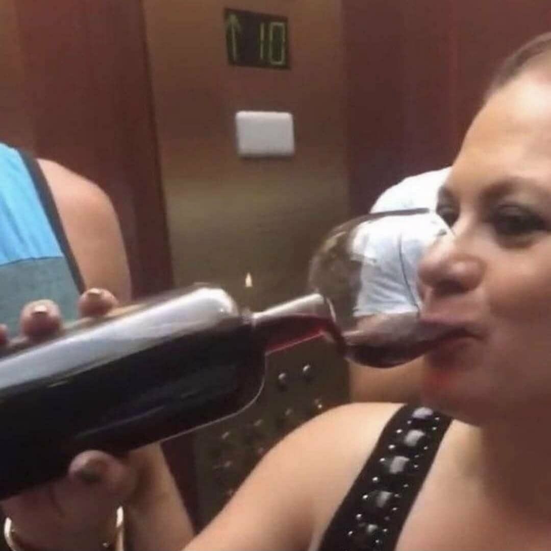 Una mujer toma vino directo de la botella que curiosamente, en lugar de terminar en pico termina en copa.