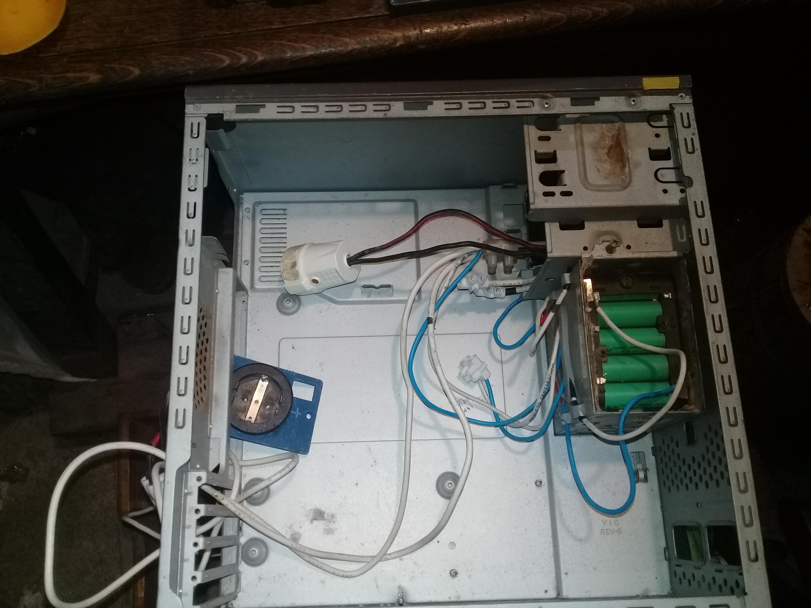 Imagen del interior de la caja de PC. Se pueden observar cables, enchufes hembra SCHUCO, al menos un pack de pilas de 3.7 voltios de una herramienta inalámbrica de 18/20 voltios.